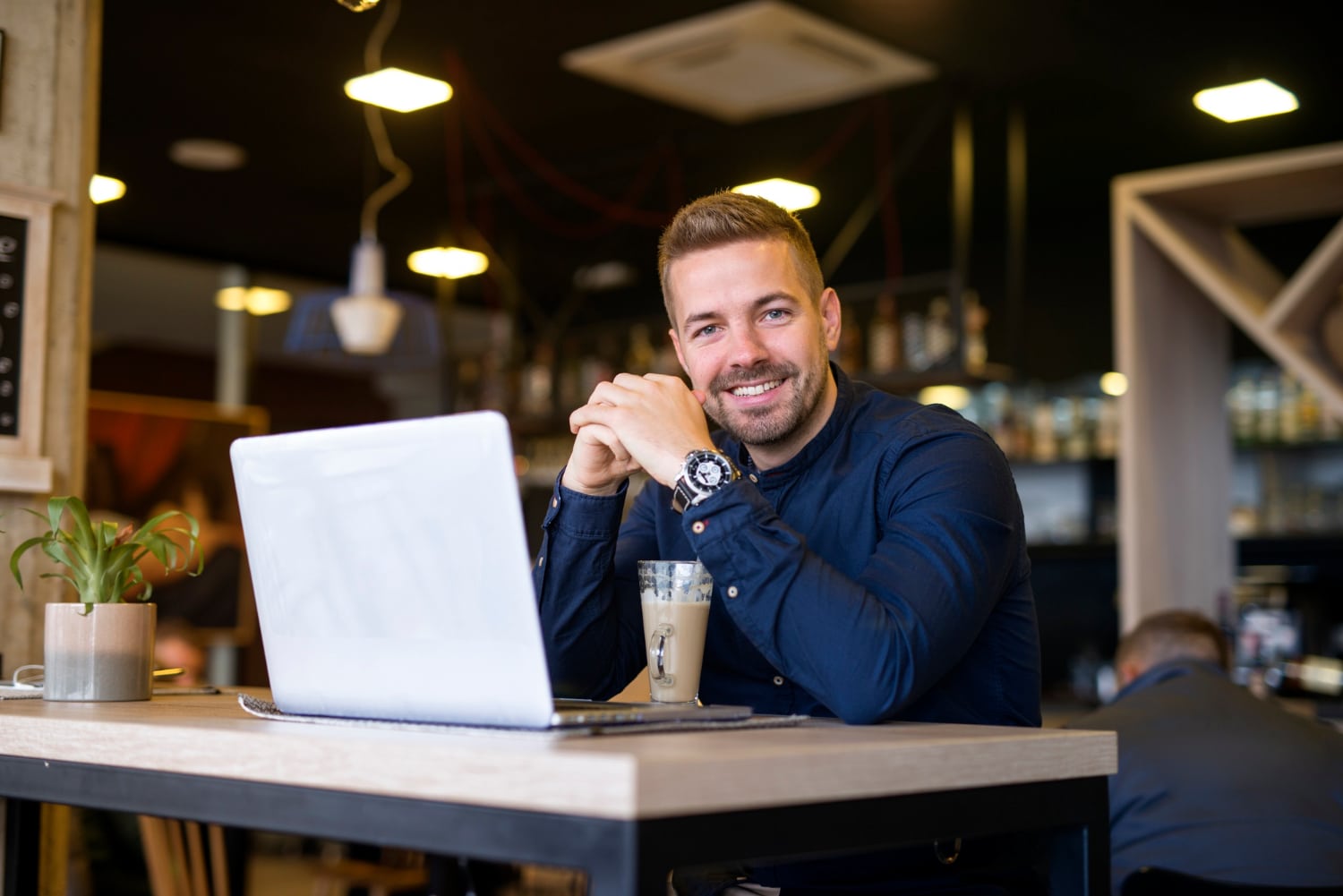 Fotografia de um empresário em frente ao seu computador sorrindo
