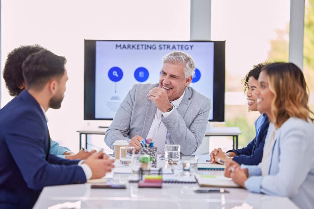 Equipe em reunião de marketing representando exemplos de marketing de relacionamento para fortalecer o vínculo com clientes.